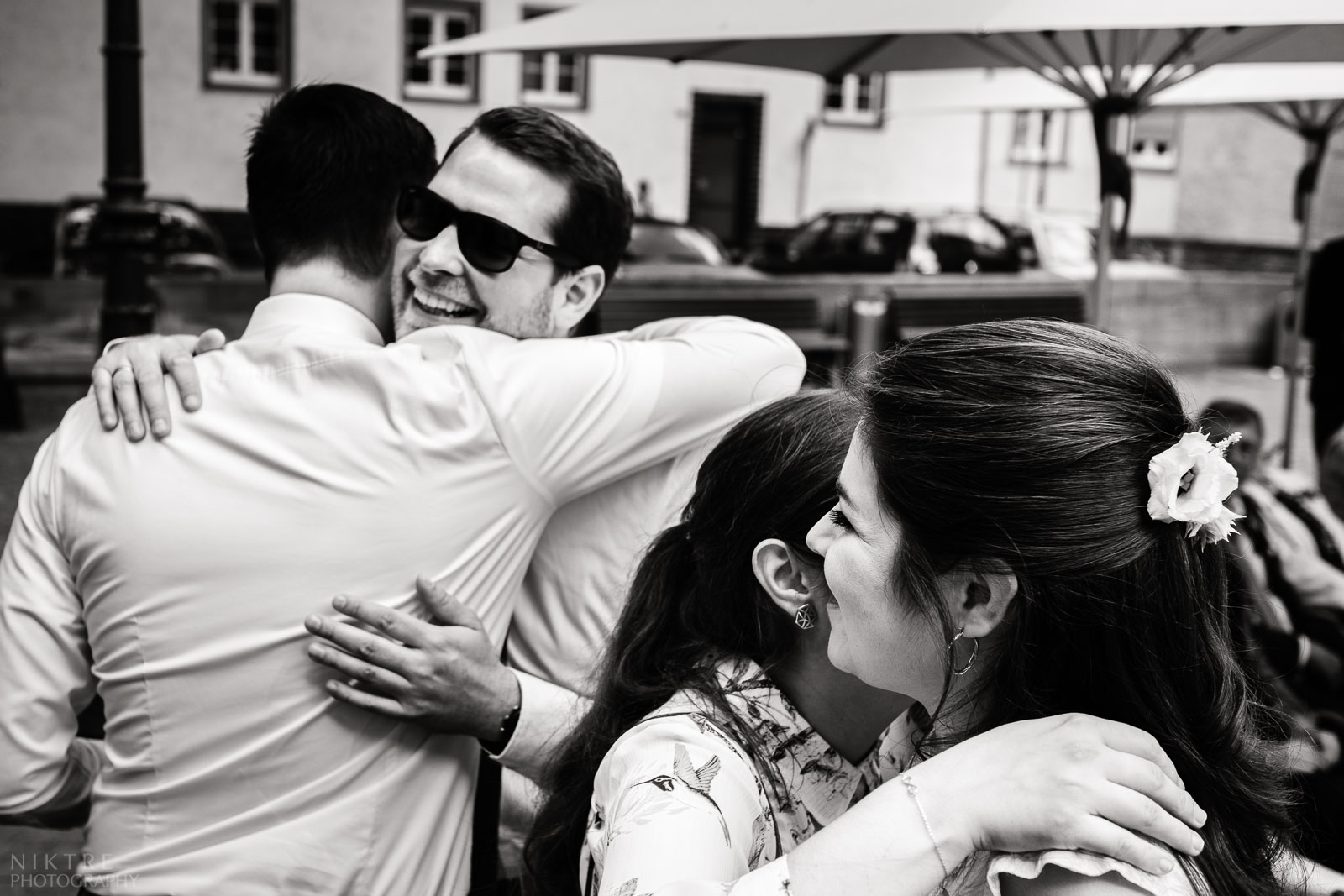 Freunde umarmen das Brautpaar während des Sektempfanges beim Willems